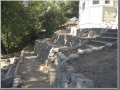 Stone retaining walls below the house hold moisture, plants and create a beautiful look